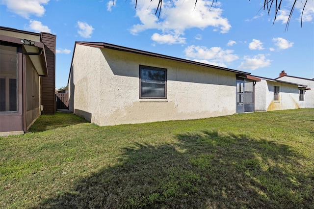 view of property exterior featuring stucco siding and a yard