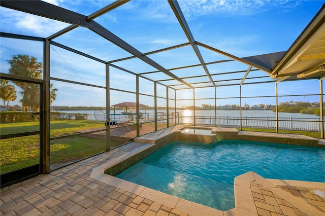 view of pool with a patio, a pool with connected hot tub, a water view, and glass enclosure