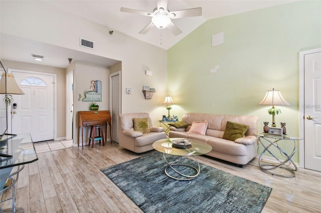 living area featuring vaulted ceiling, ceiling fan, light wood-style flooring, and visible vents