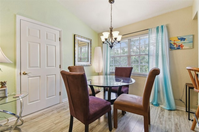 dining area featuring lofted ceiling, baseboards, light wood-style flooring, and an inviting chandelier