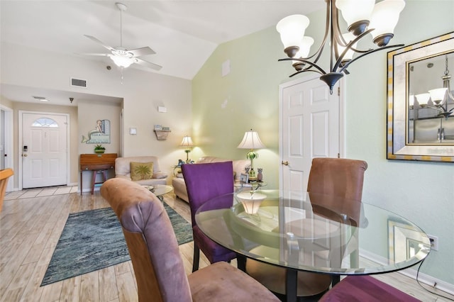 dining area featuring visible vents, vaulted ceiling, wood finished floors, baseboards, and ceiling fan with notable chandelier