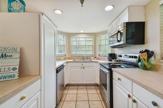 kitchen featuring light tile patterned floors, stainless steel appliances, a sink, and light countertops