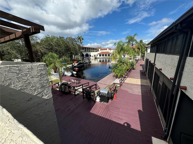 wooden deck featuring a water view and a boat dock