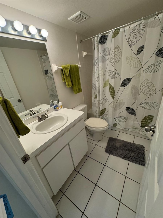 bathroom with visible vents, toilet, vanity, a shower with curtain, and tile patterned floors