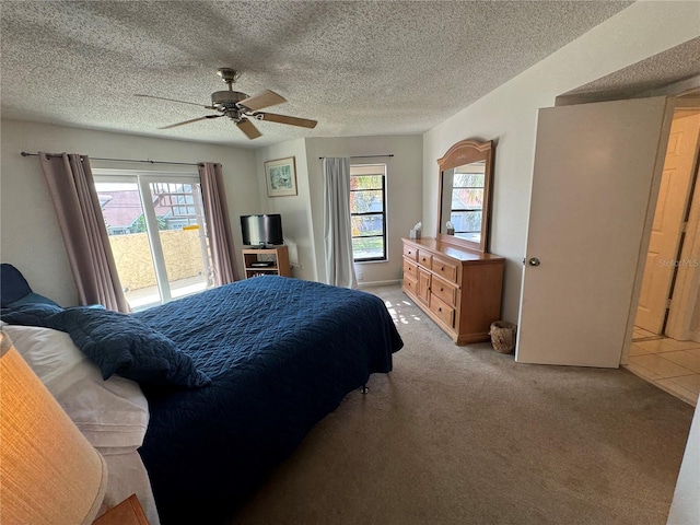 bedroom with a textured ceiling, ceiling fan, multiple windows, and carpet