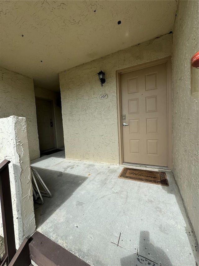 entrance to property featuring stucco siding