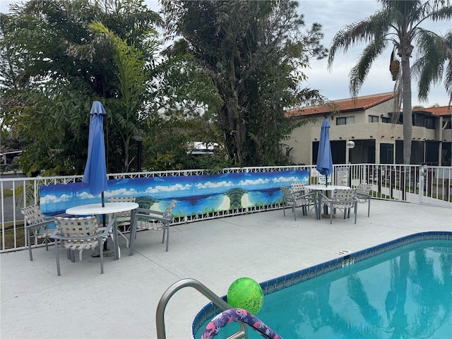 community pool featuring a patio area and fence