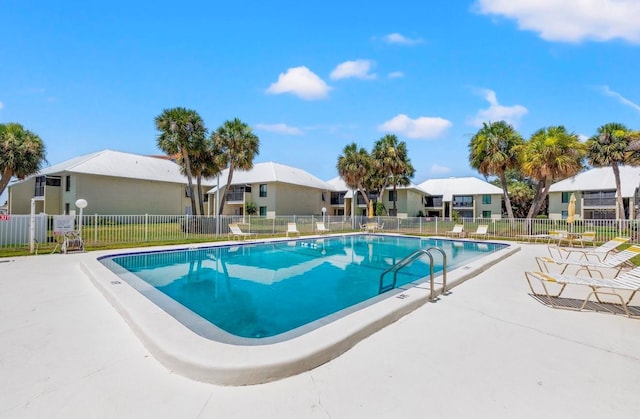 pool featuring a patio, fence, and a residential view