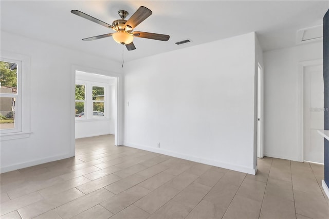 empty room with baseboards, visible vents, and a ceiling fan