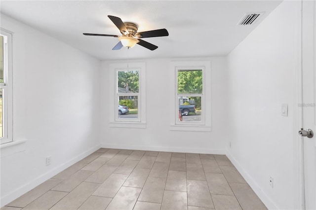 spare room featuring baseboards, visible vents, and a ceiling fan