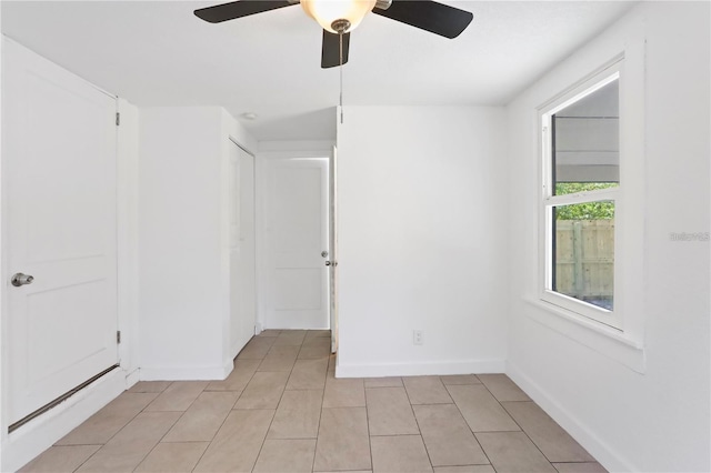 unfurnished room featuring light tile patterned floors, baseboards, and a ceiling fan