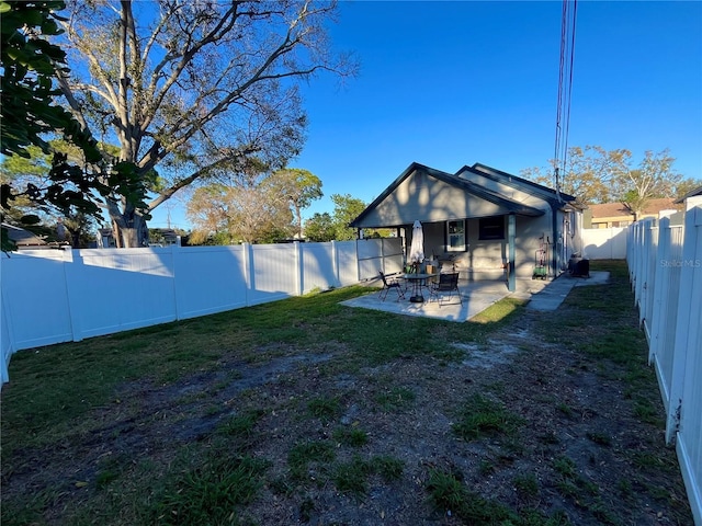 rear view of property with a lawn, a patio area, and a fenced backyard