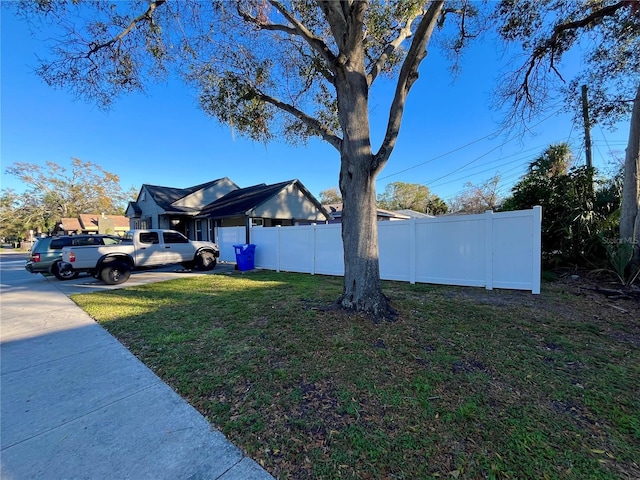 view of side of property featuring a yard and fence