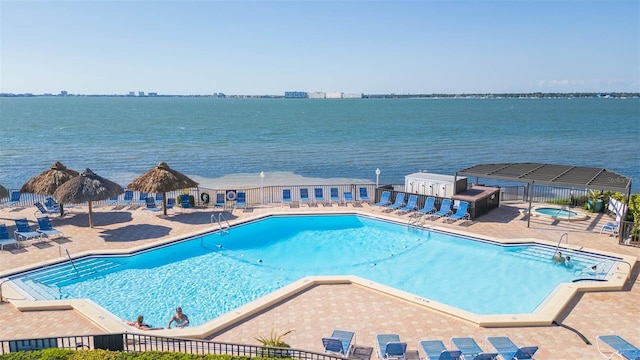 community pool with a patio, a water view, a hot tub, a gazebo, and fence