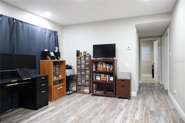 office space featuring baseboards and light wood finished floors