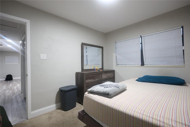 bedroom with light carpet and baseboards