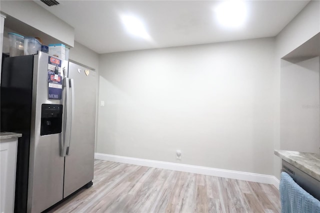 kitchen featuring light wood-style flooring, baseboards, stainless steel refrigerator with ice dispenser, and light countertops