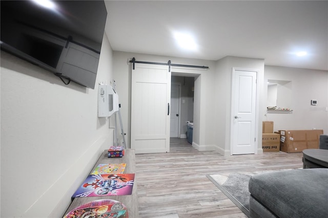 interior space featuring a barn door, baseboards, and light wood-style flooring