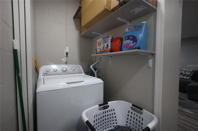 washroom featuring concrete block wall, washer / clothes dryer, and laundry area