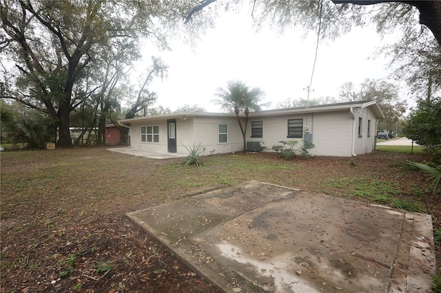 rear view of house with central AC unit and a patio area