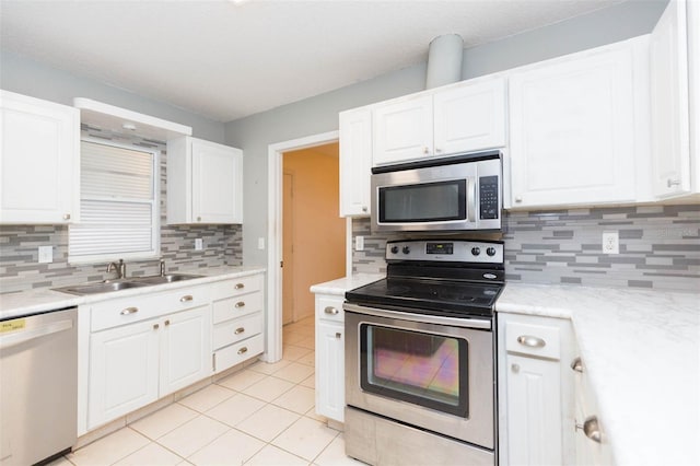 kitchen with stainless steel appliances, a sink, and white cabinets