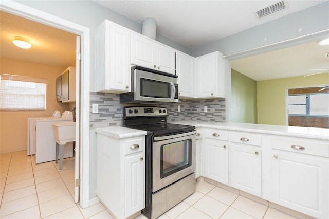 kitchen with white cabinetry, stainless steel appliances, separate washer and dryer, and light countertops