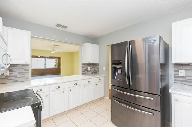 kitchen with visible vents, white cabinets, stainless steel fridge with ice dispenser, backsplash, and light tile patterned flooring