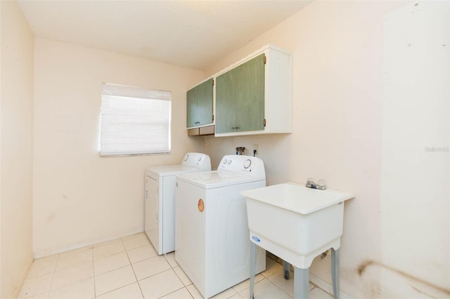 laundry room featuring cabinet space, a sink, washing machine and clothes dryer, and light tile patterned floors