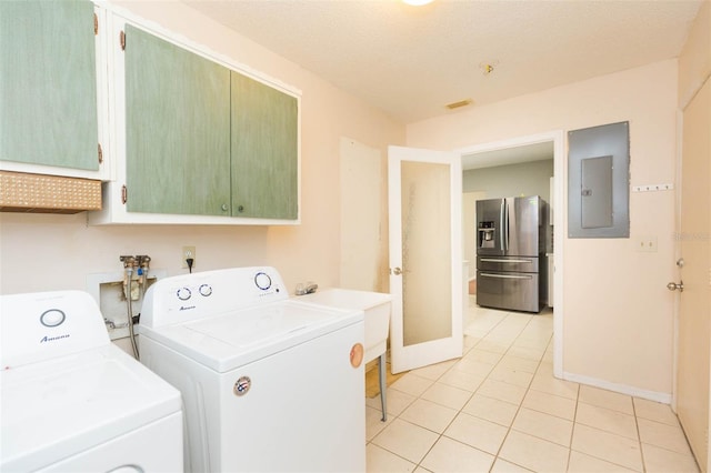 washroom featuring light tile patterned floors, washing machine and dryer, baseboards, cabinet space, and electric panel