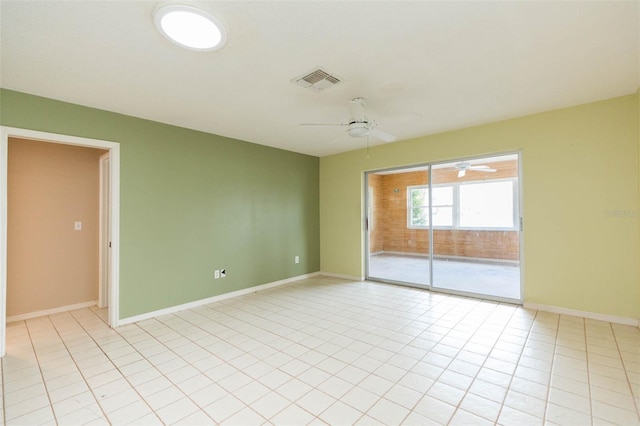 unfurnished room with light tile patterned floors, baseboards, visible vents, and a ceiling fan