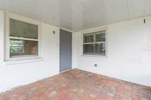 property entrance with a patio and stucco siding