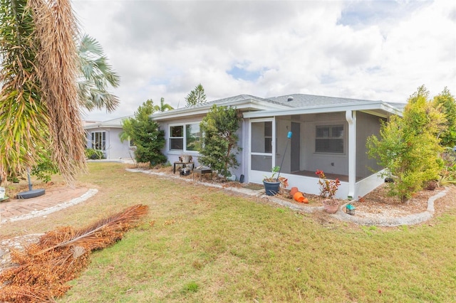 single story home with a front yard and a sunroom