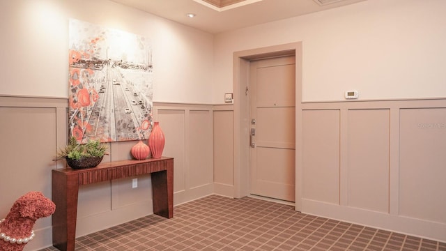 interior space featuring a wainscoted wall and a decorative wall