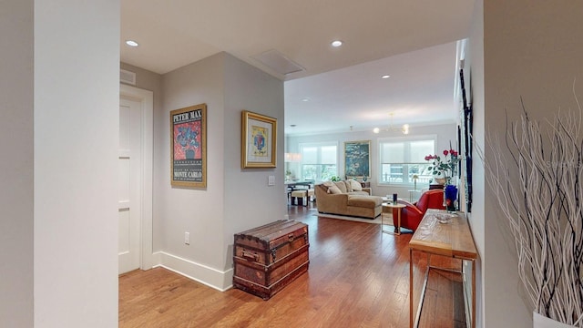 corridor featuring light wood-type flooring, baseboards, and recessed lighting