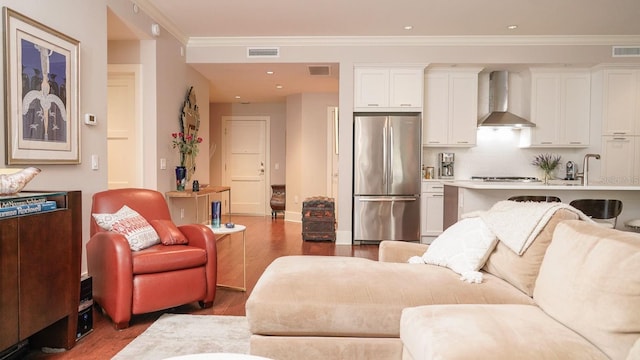 living room featuring visible vents, crown molding, and wood finished floors