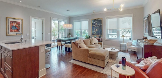 living area featuring baseboards, dark wood finished floors, crown molding, and a chandelier