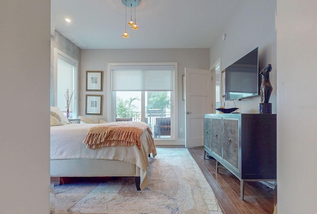 bedroom featuring access to exterior and wood finished floors