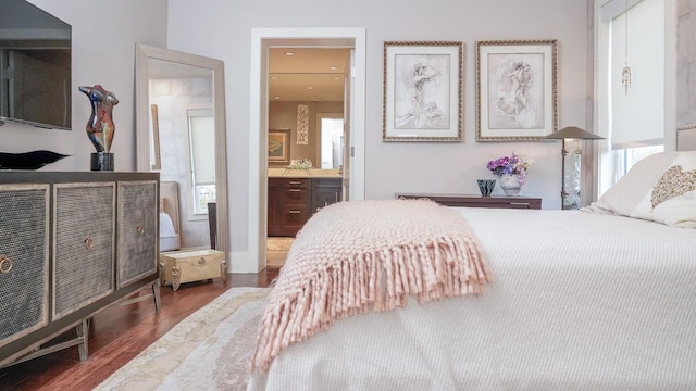 bedroom with multiple windows, wood finished floors, and ensuite bathroom