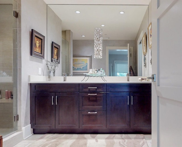 bathroom featuring double vanity, a stall shower, and recessed lighting