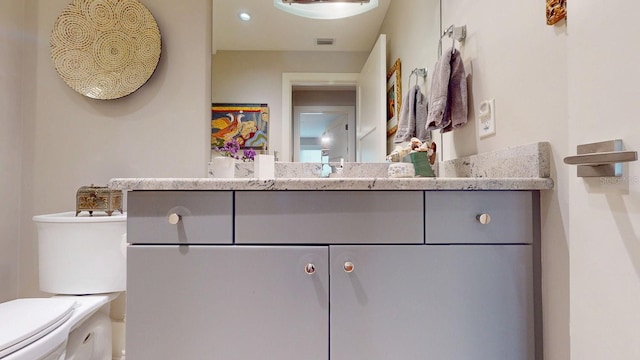 bathroom with visible vents, vanity, and toilet