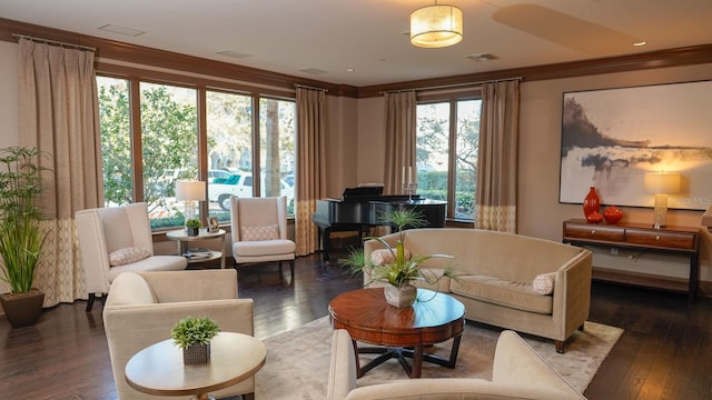 sitting room with visible vents, wood finished floors, and ornamental molding