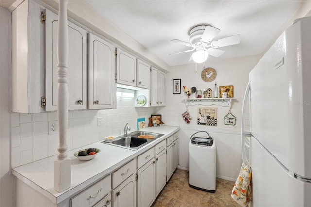 kitchen featuring light countertops, backsplash, freestanding refrigerator, a sink, and ceiling fan