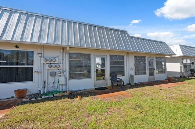 view of front facade featuring metal roof and a front lawn