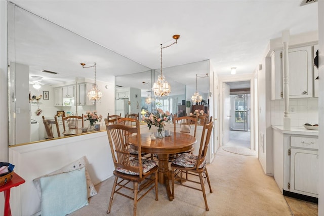 dining space featuring visible vents, a chandelier, and light colored carpet