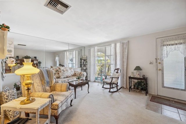 living area with visible vents and light colored carpet