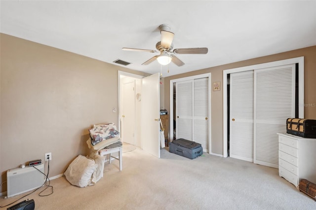 interior space featuring light carpet, ceiling fan, and visible vents