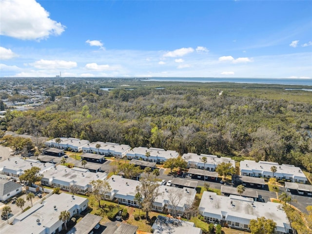 drone / aerial view with a residential view, a water view, and a view of trees