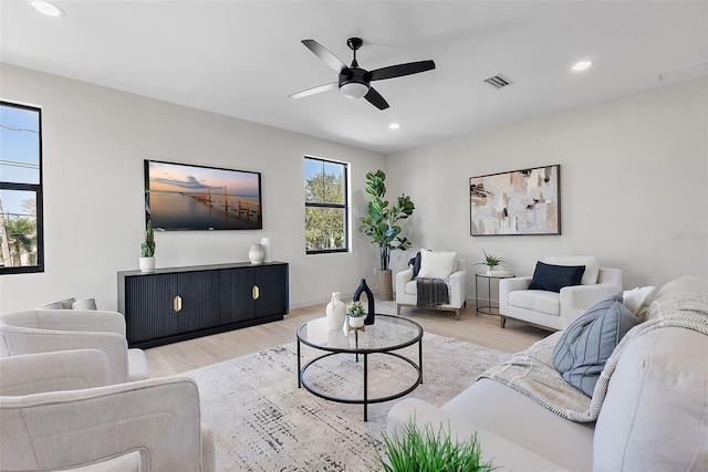 living area with a ceiling fan, wood finished floors, visible vents, and recessed lighting