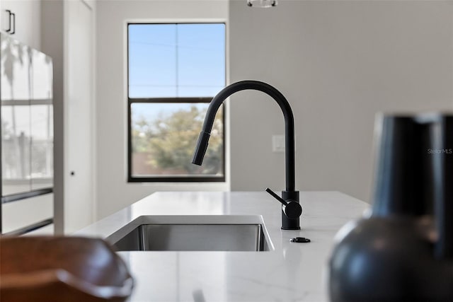 interior details with light countertops, a sink, and freestanding refrigerator