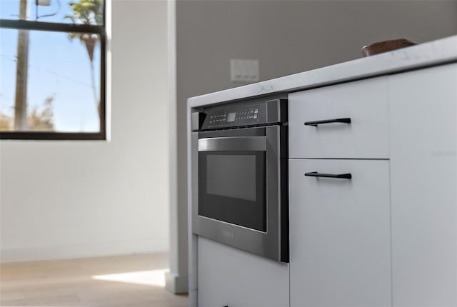 interior details featuring stainless steel oven and white cabinets